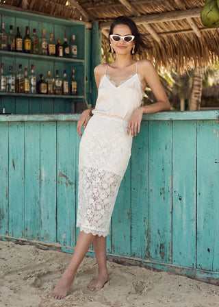Cami NYC Aylin Lace Midi Skirt White. Model is wearing the product on a blue background. 