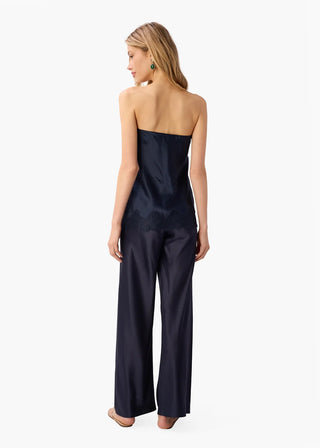 Cami NYC Bristol Mid Rise Pant Dark Wash. Model is wearing product and is turned around posing in front of a white background. 