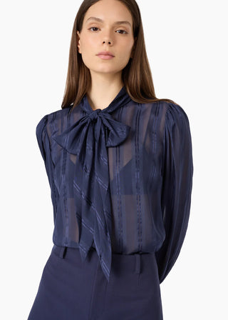 Cami NYC Rema Jacquard Top Navy. Model is posing in front of white background in product. 