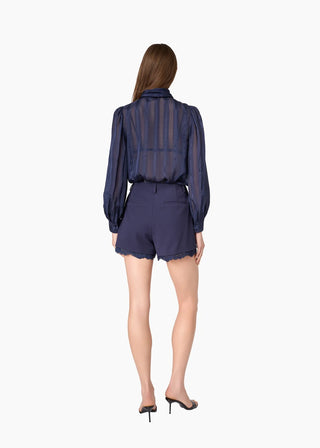 Cami NYC Rema Jacquard Top Navy. Model is turned around while wearing the product and image is shot on white background.