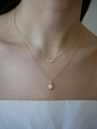 Two gold necklaces with pendants on a person's neck against a white background EF Collection Graduated Diamond Arc Necklace