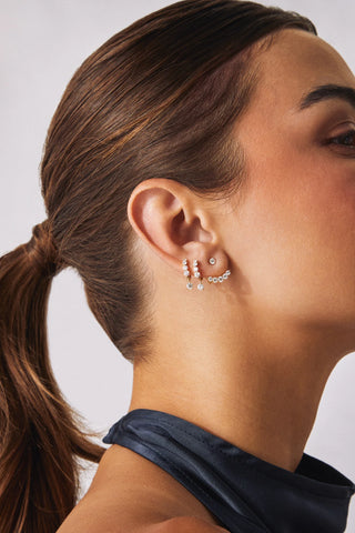 Close-up of a woman wearing a set of earrings with a neutral background  wearing EF Collection Graduated Diamond Ear Jacket