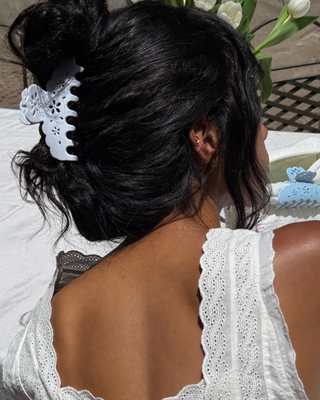 Emi Jay Big Effing Claw Clip in Blanc Fleur Eyelet. Model is wearing the hair clip and this image is shot outside. 
