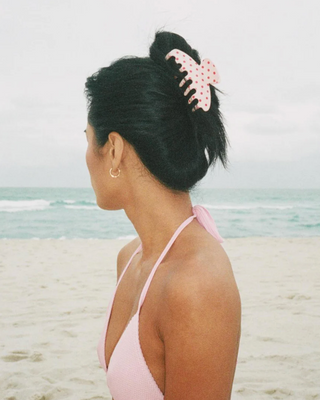 Emi Jay Big Effing Claw Clip in Blush Polka Dot. Model wearing the hair clip on the beach. 