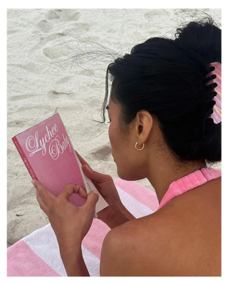 Emi Jay Big Effing Claw Clip in Lychee Baby. Model reading while wearing hair clip.