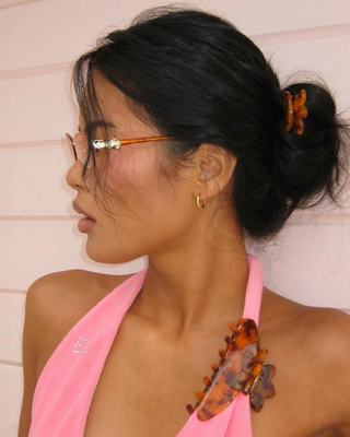 Emi Jay Big Effing Claw Clip in Tortoise Hibiscus. Product displayed on model's bathing suit. 