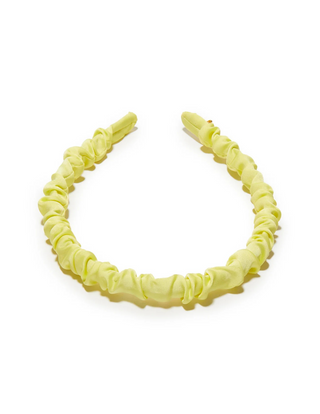 Lele Sadoughi Prickly Pear Jessie Silk Headband laid flat, with smooth silk yellow fabric.