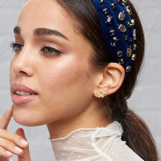 Woman wearing Lele Sadoughi Gold Star Stud Holiday Earrings Star of David Earrings