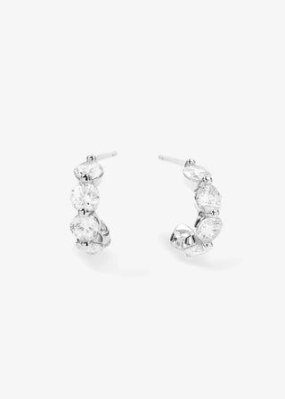Close-up of small silver hoop earrings featuring sparkling white diamondette stones