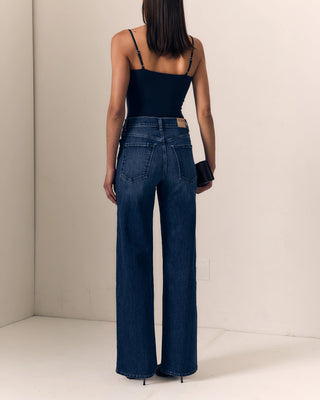 Le Jean Column Jean. Model is turned around posing in the jeans in front of a white background. 
