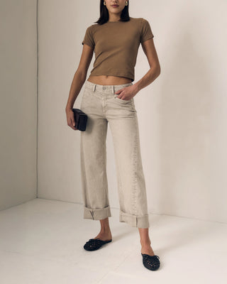 Le Jean Selena Crop Cuffed Mid Rise. Model is wearing the product and is posing in front of a white background. 