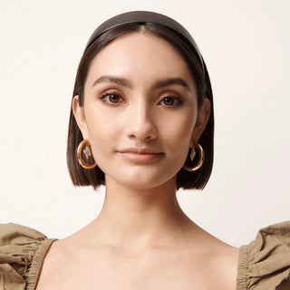 Lele Sadoughi Jet Faux Leather Bessette Headband. Model is wearing product shot on white background. 