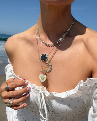 Melinda Maria She's An Icon Gold Labradorite Moon Necklace. Model is wearing the necklace along with other ones.