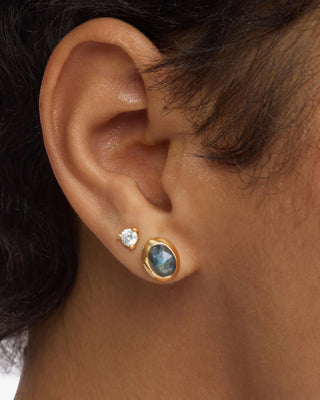 Melinda Maria She's a Boss Studs 8mm Gold Labradorite. Image is shot up close of model's ear with the earring on. 