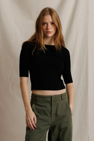 Perfect White Tee Amelia Short Sleeve Luxe Rib True Black. Model is posing in front of a white background wearing the product. 