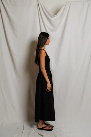 Perfect White Tee Fabiola Cotton Poplin Sleeveless Dress True Black. Model is wearing the dress and she's turned to the side. Image is shot on white background. 