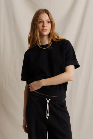 Perfect White Tee Kennedy Vintage Black. Model is posing in front of a white background in the product. 