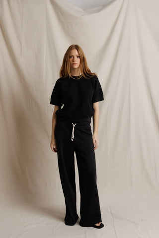 Perfect White Tee Kennedy Vintage Black. Model is posing in front of a white background in the product. 