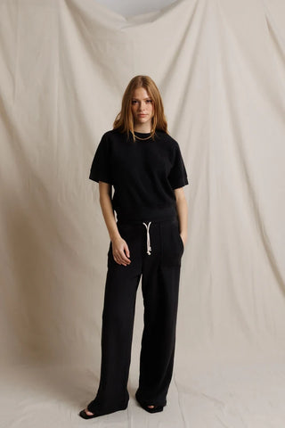 Perfect White Tee Kennedy Vintage Black. Model is posing in front of a white background in the product. 