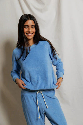 Perfect White Tee Saylor Loop Terry Sweatshirt Pacific Blue. Model is posing wearing the product and smiling. 
