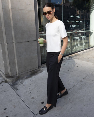 Ripley Rader Black Ponte Knit Barrel Pant. Model is wearing product and she's on the street with a coffee.