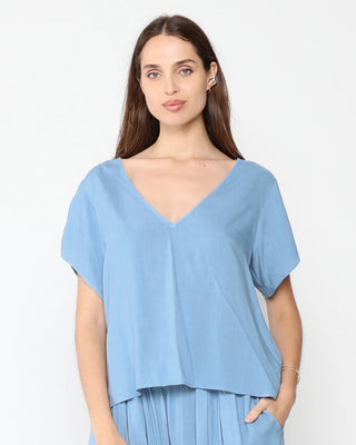 Ripley Rader Chambray Linen Everyday V Neck. Model is posing on a white background in the product. 