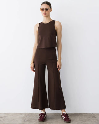 Ripley Rader Chocolate Ponte Knit Cropped Wide Leg Pant. Model is posing in front of a white background in pants. 