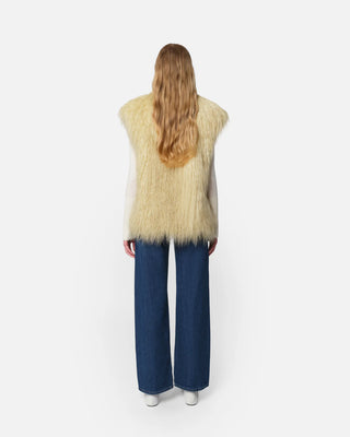 The model is wearing the Apparis Laila Mongolian Pannacotta Faux Fur vest