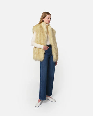 The model is wearing the Apparis Laila Mongolian Pannacotta Faux Fur vest