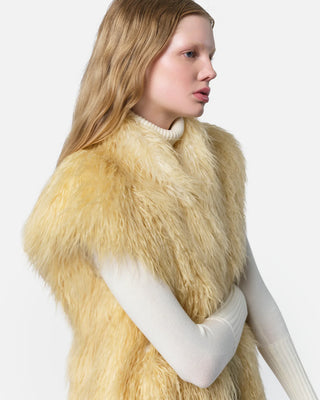 The model is wearing the Apparis Laila Mongolian Pannacotta Faux Fur vest