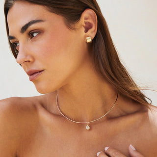 Woman wearing  ef collection fluted stud gold earrings and necklace against a neutral background